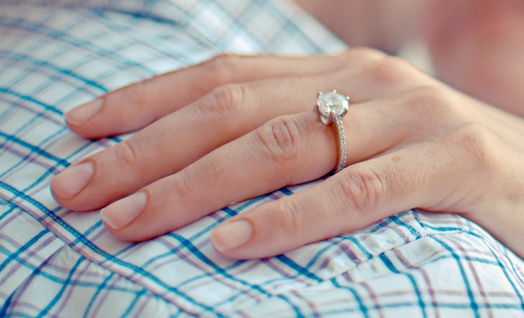 Hand wearing a solitaire engagement ring